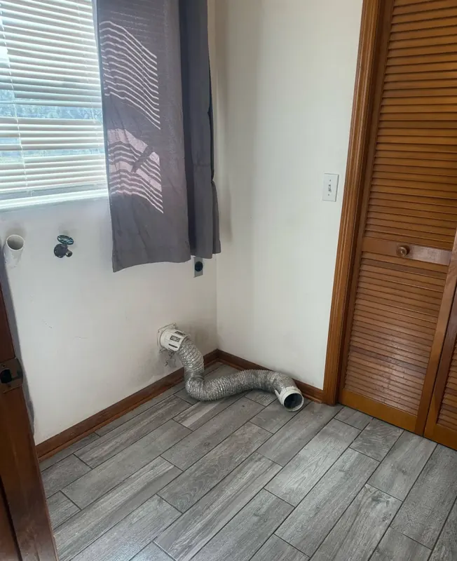 Tidy laundry room corner with clean tile floors