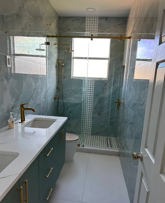 Modern bathroom with teal marble walls and gold fixtures