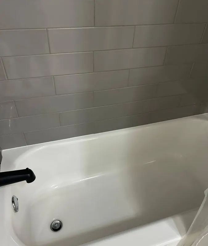 Pristine white bathtub with subway tile surround